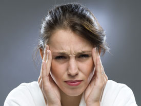 A woman holding her head in front of her face.